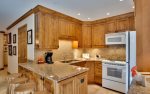 Fully equipped kitchen with breakfast bar seating for four.